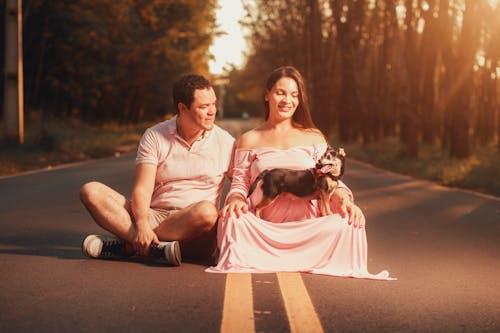 A Couple Sitting Outdoors with Their Dog 