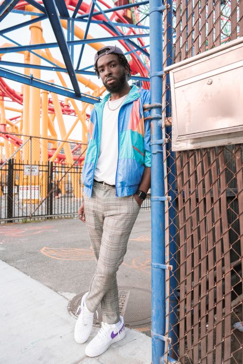 Free Fashionable man in colorful jacket posing at Coney Island amusement park, NYC, showcasing street style Stock Photo