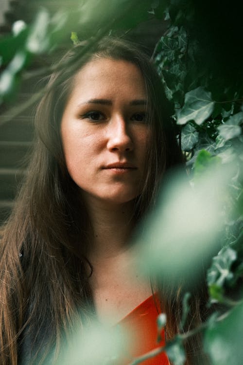 Portrait of a Young Brunette Woman Seen Though Tree Leaves