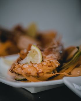 Close-up of a gourmet grilled lobster tail garnished with a lemon slice, highlighting culinary artistry.