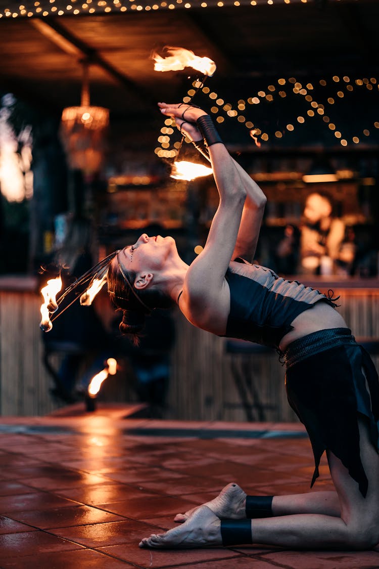 Woman Performer In Black Corset Dancing With Fire