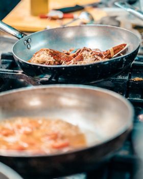 Gourmet lobster being cooked in a frying pan, showcasing culinary artistry.
