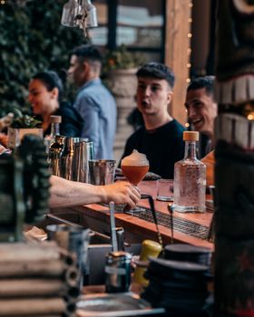 Energetic nightlife moment capturing a bartender serving drinks at a bustling bar.