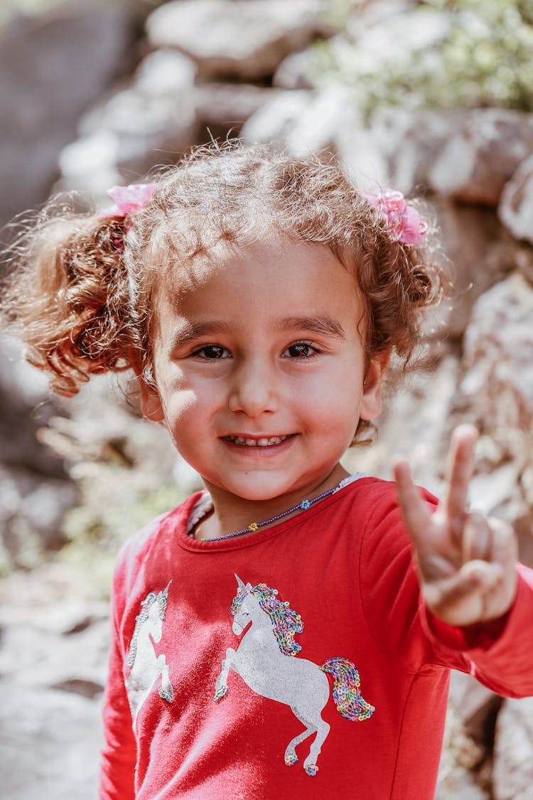 Portrait Of A Small Girl Smiling And Gesturing