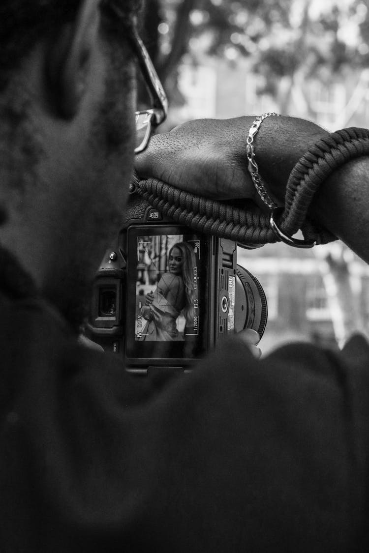 Fashion Photographer Watching A Young Woman In His Camera Viewfinder Screen