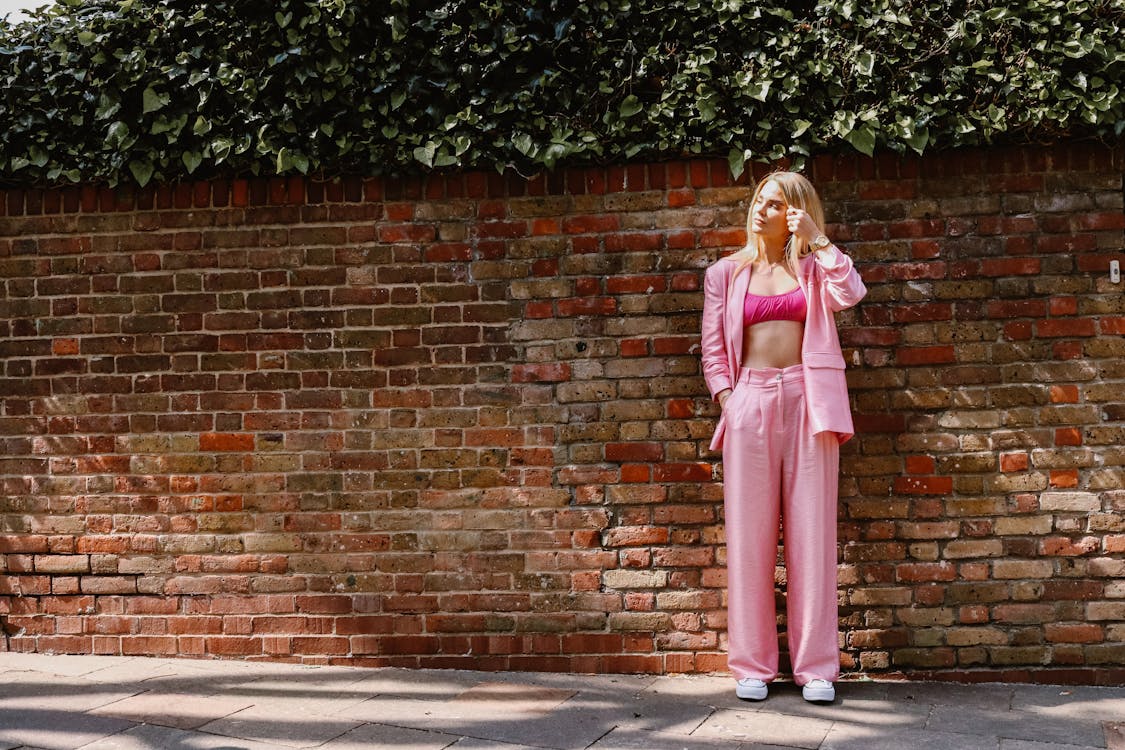 A woman in pink pants and a top posing for a photo · Free Stock Photo
