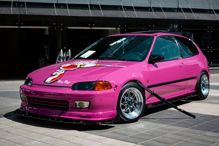 Photo Of A Pinkish Car With A Sticker