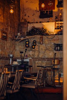 Warm and inviting vintage bar with stone walls, wine bottles, and vinyl decor.