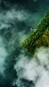Captivating aerial shot showcasing Polańczyk's lush greenery and serene lake views on a misty day.