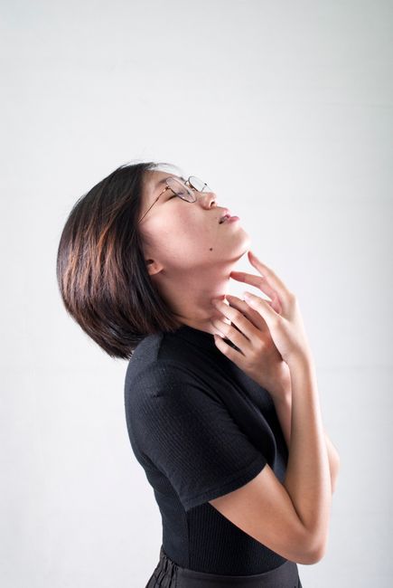Side view portrait of a young woman with short hair wearing eyeglasses, eyes closed in a serene pose.