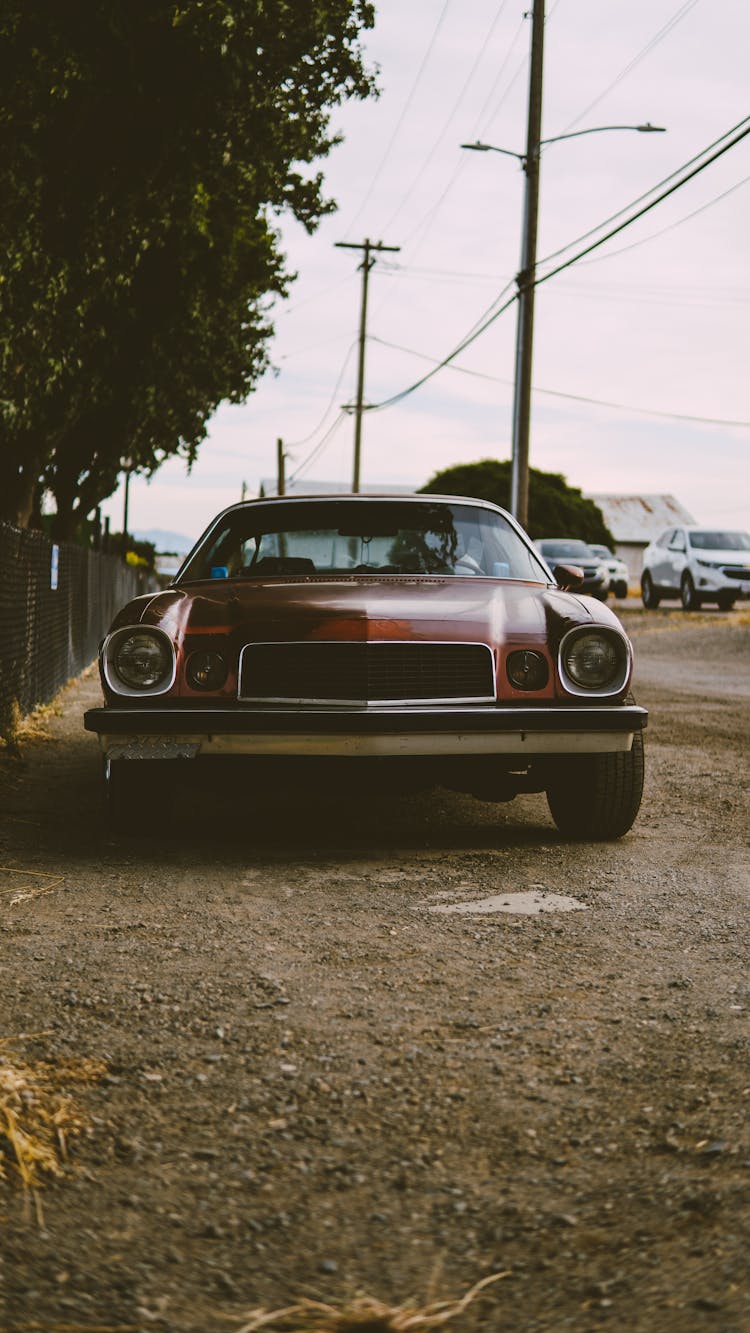 Red Vintage Chevrolet Camaro Parked On A Roadside