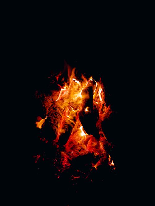 Free Captivating image of a campfire burning brightly at night with vibrant flames against a dark backdrop. Stock Photo
