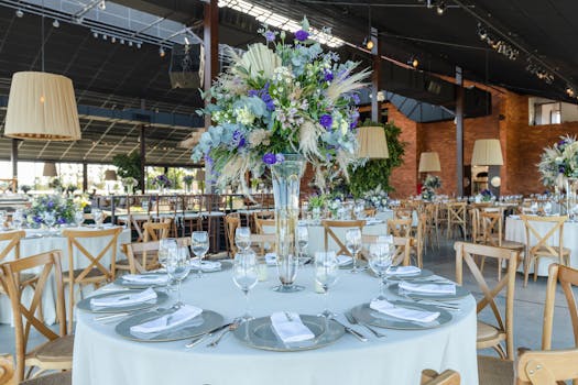 Luxurious wedding reception setup with a floral centerpiece and elegant table setting.
