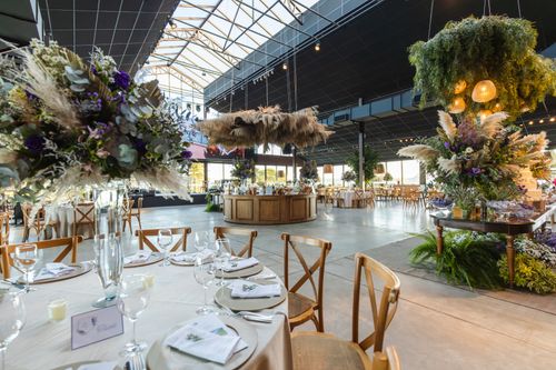 Free A beautifully decorated indoor wedding venue with floral arrangements and elegant table settings. Stock Photo