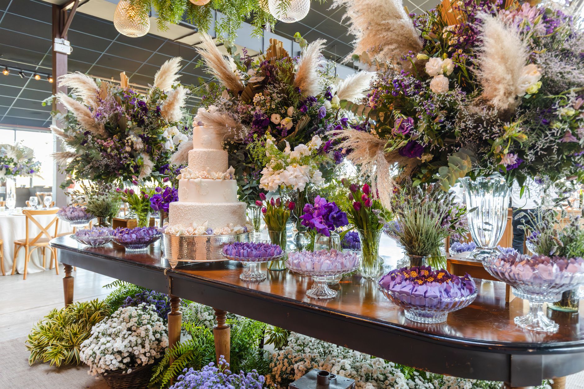 Luxurious wedding table setup with a multi-tiered cake and stunning floral arrangements.