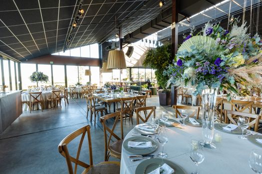 Spacious wedding venue featuring floral decor, elegant table settings, and rustic charm.