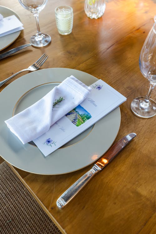 Luxury Restaurant Table with a Menu and Napkin Lying on a Plate 