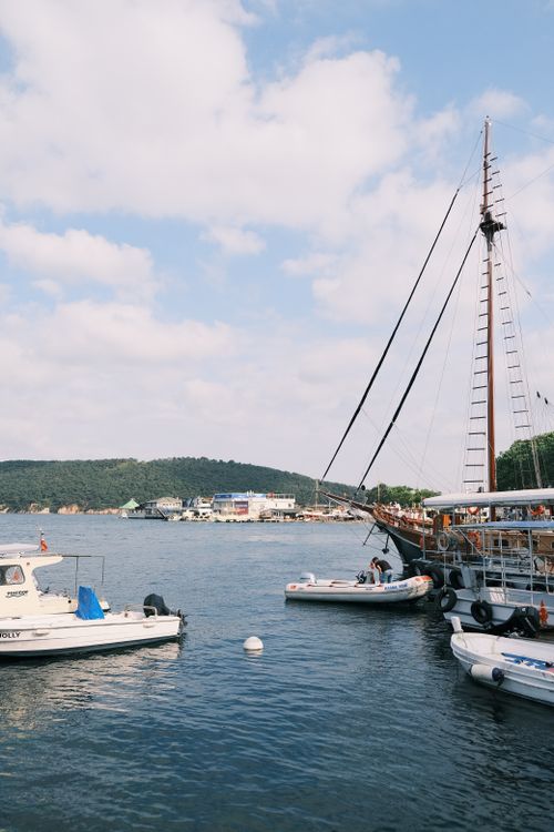 Free Idyllic summer day at a picturesque harbor with motorboats and sailing ships. Stock Photo