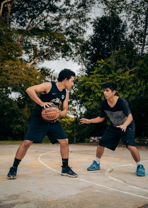 Free Two young men engaged in a tense basketball game on an outdoor court in Ríoja, Perú. Stock Photo