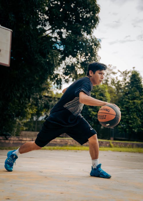 Basketball Player Running on a Court with a Ball