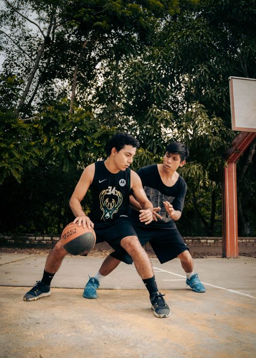 Free Two young men playing basketball in an outdoor court in Rioja, Peru, showcasing intense action. Stock Photo
