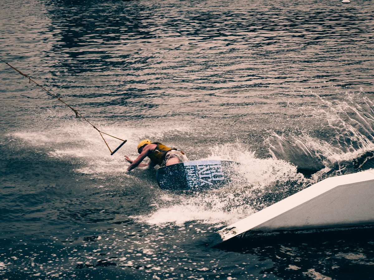 Wakeboarder spraying water as they carve on a lake