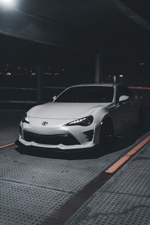 Free A stylish white Toyota sports car parked in a dimly lit underground garage at night, exuding elegance and sophistication. Stock Photo