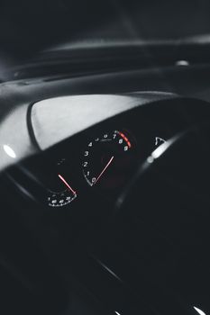 Close-up view of an illuminated car speedometer at night, showcasing sleek interior design.