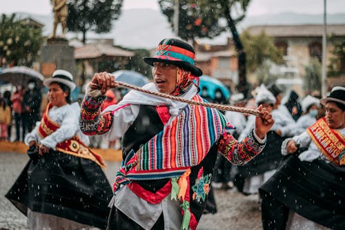 Man and Dancers in Traditional Clothing in Rain