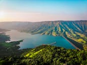 日落时分，郁郁葱葱的山丘和山脉环绕着湖泊，非常适合旅行爱好者