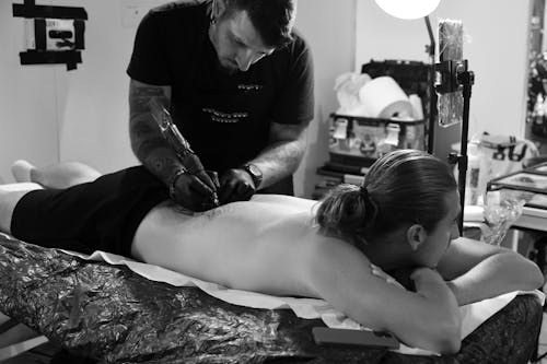 Man Making a Tattoo on Back in Studio