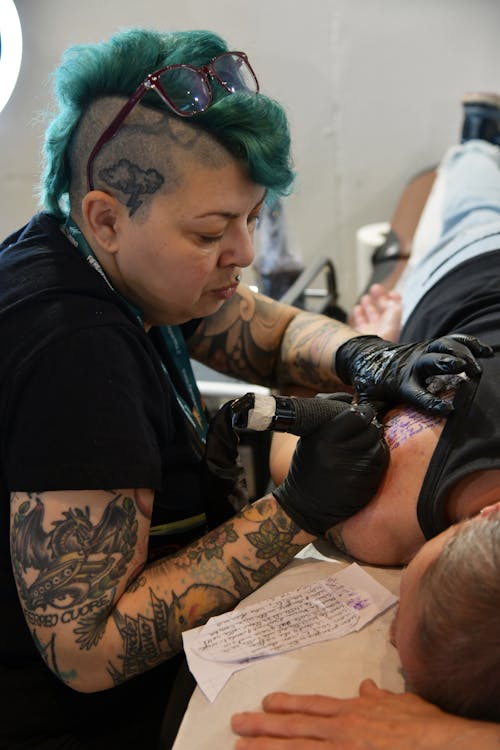 Woman Making a Tattoos on Shoulder in Studio