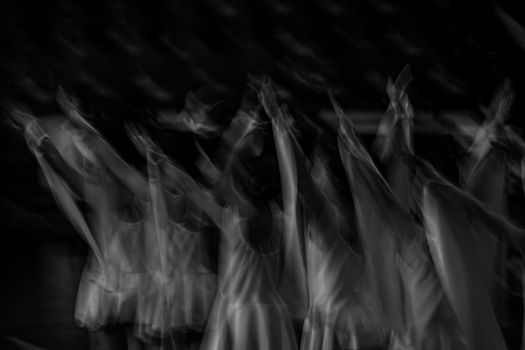A surreal black and white image capturing ballet dancers in motion, creating a fluid and ghostly effect.