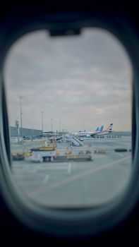 Airplanes parked at Dubai Airport as seen from an airplane window.