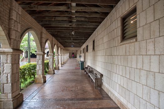 A long walkway with benches and arches
