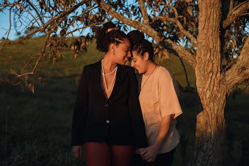 Free Two Women Standing Outside, Holding Hands and Smiling  Stock Photo