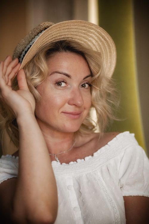 Free Portrait of a smiling woman in a straw hat, capturing a warm, natural moment. Stock Photo