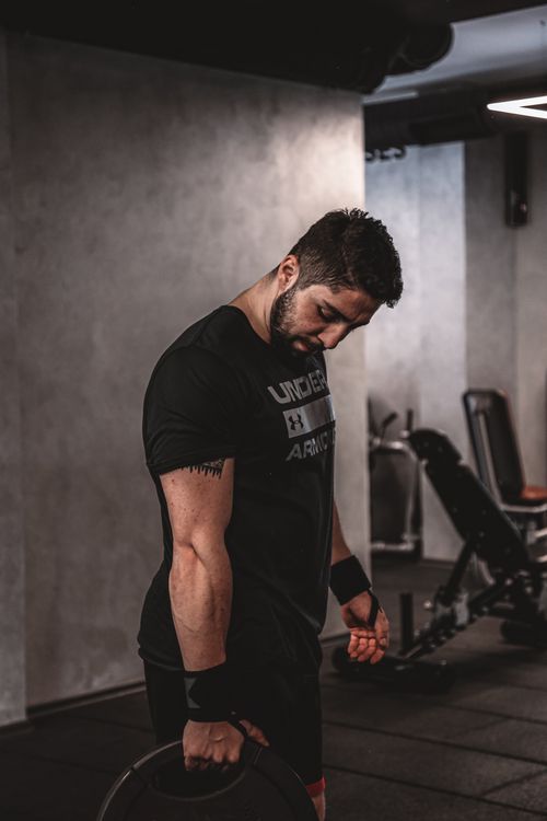 Free Male athlete focusing during weight training session in a gym setting. Stock Photo