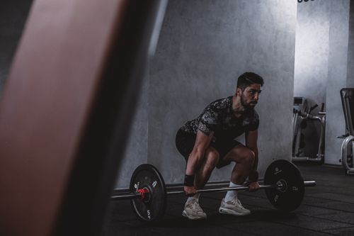 Free Man lifting weights in gym, displaying strength and focus. Ideal for fitness and training themes. Stock Photo