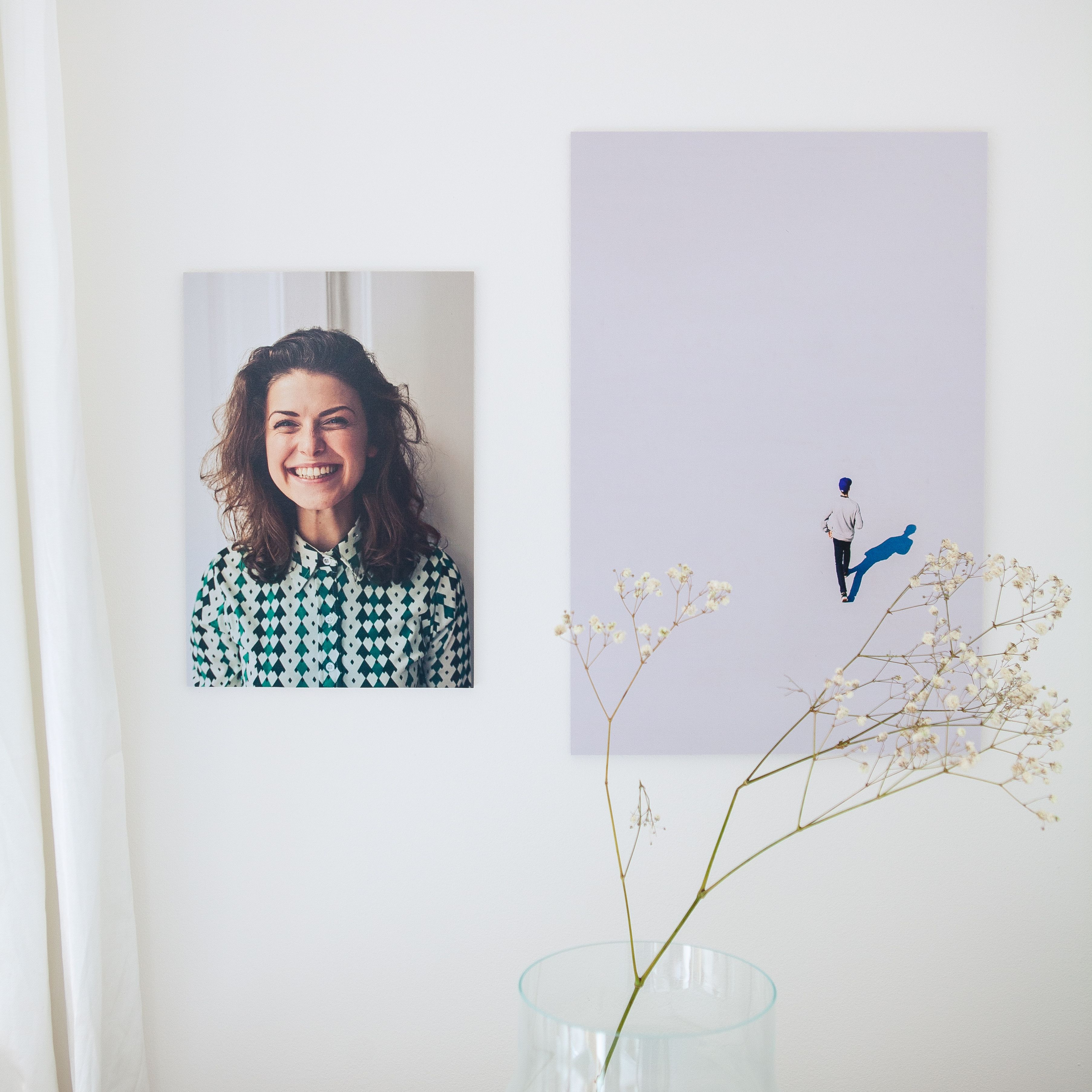 Minimalist decor featuring a smiling portrait and contemporary art on a white wall.