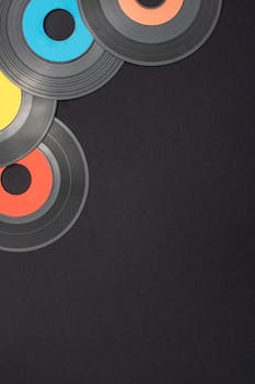 Retro vinyl records with colorful labels on a black backdrop, providing copy space.