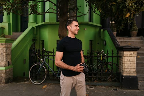 Photographer Standing on Street under Green Building