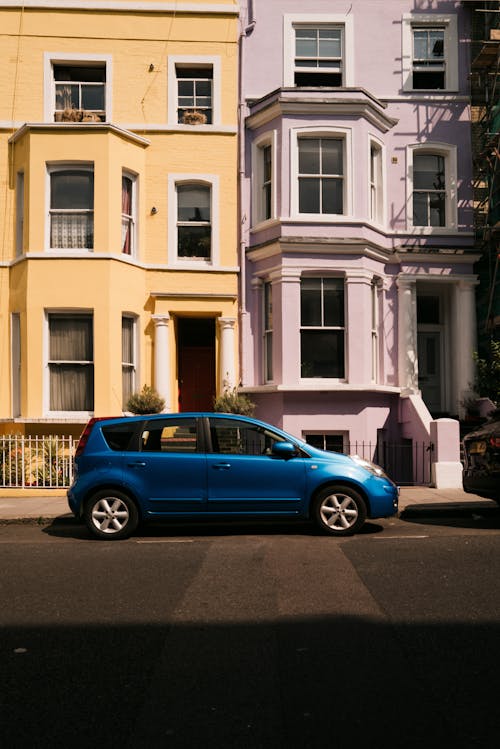 Blue Nissan Note Parked on Street under Townhouses