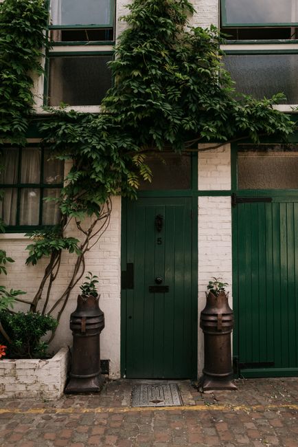 Cozy London street scene showing a green door adorned with ivy.