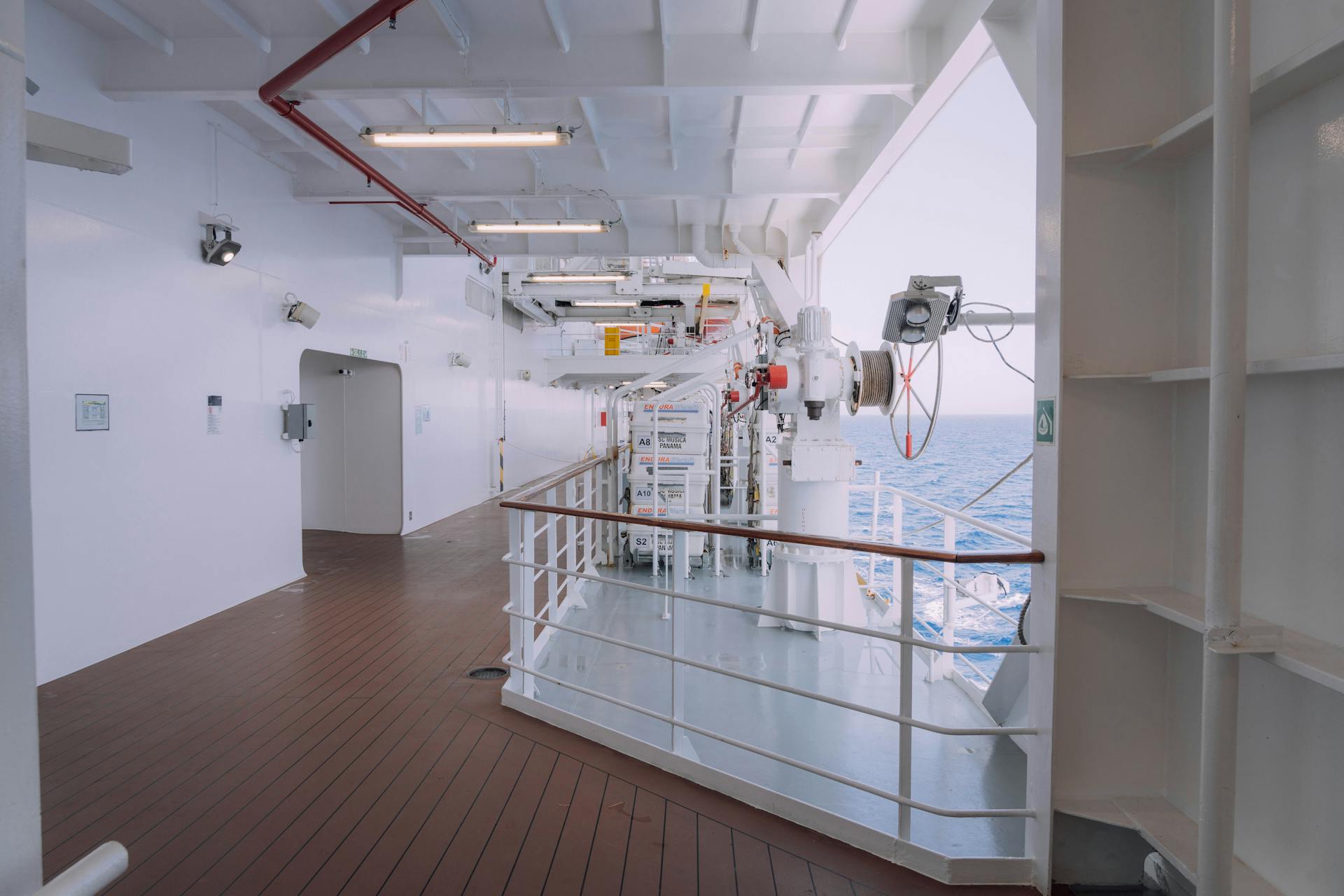 Spacious cruise ship deck featuring safety equipment and ocean view, ideal for travel themes.