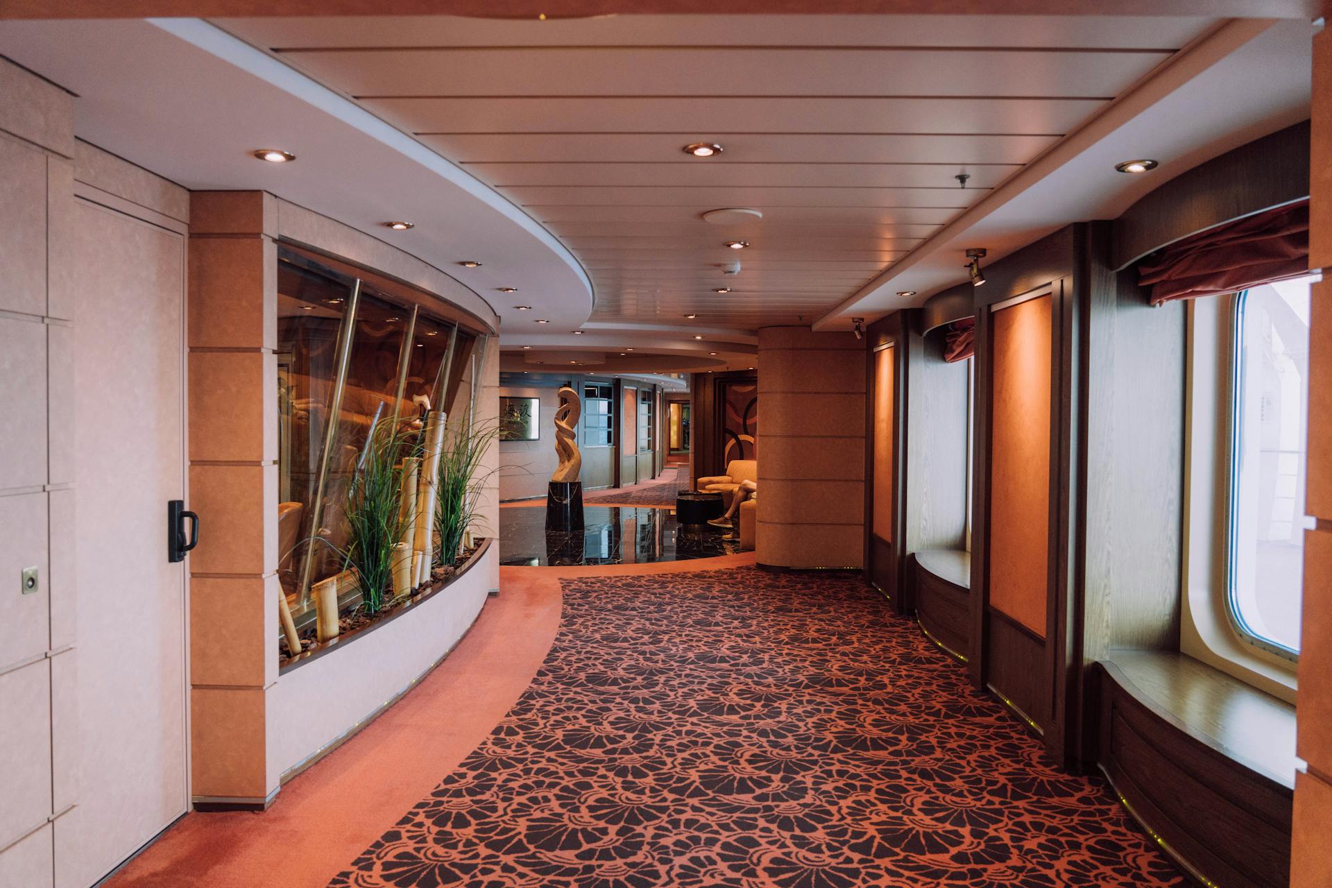Elegant empty corridor interior of a luxury cruise ship with stylish design.