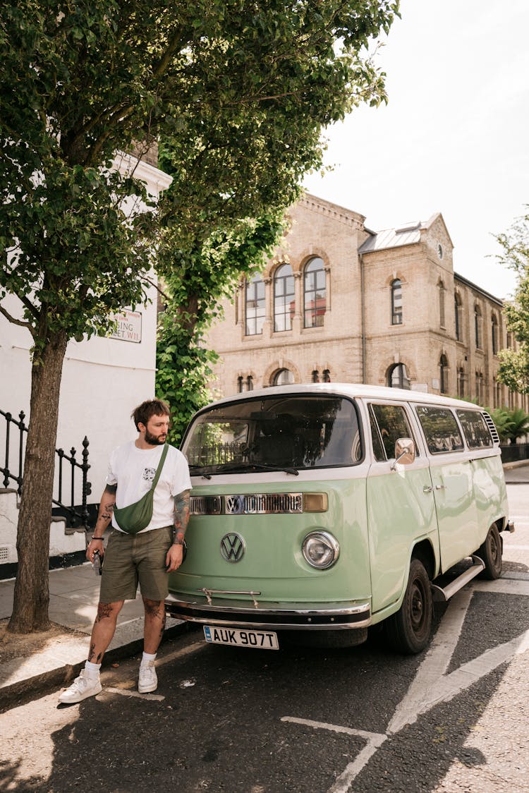 Man In Front Of Green Van On A Street 