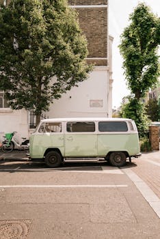 Classic Volkswagen van parked on a sunny London street, evoking a nostalgic urban vibe.