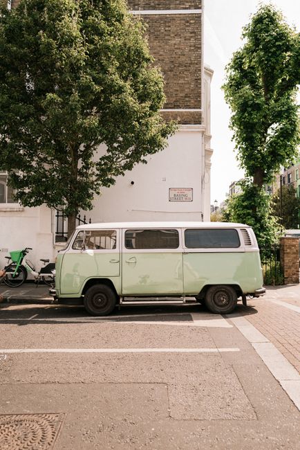 Classic Volkswagen van parked on a sunny London street, evoking a nostalgic urban vibe.