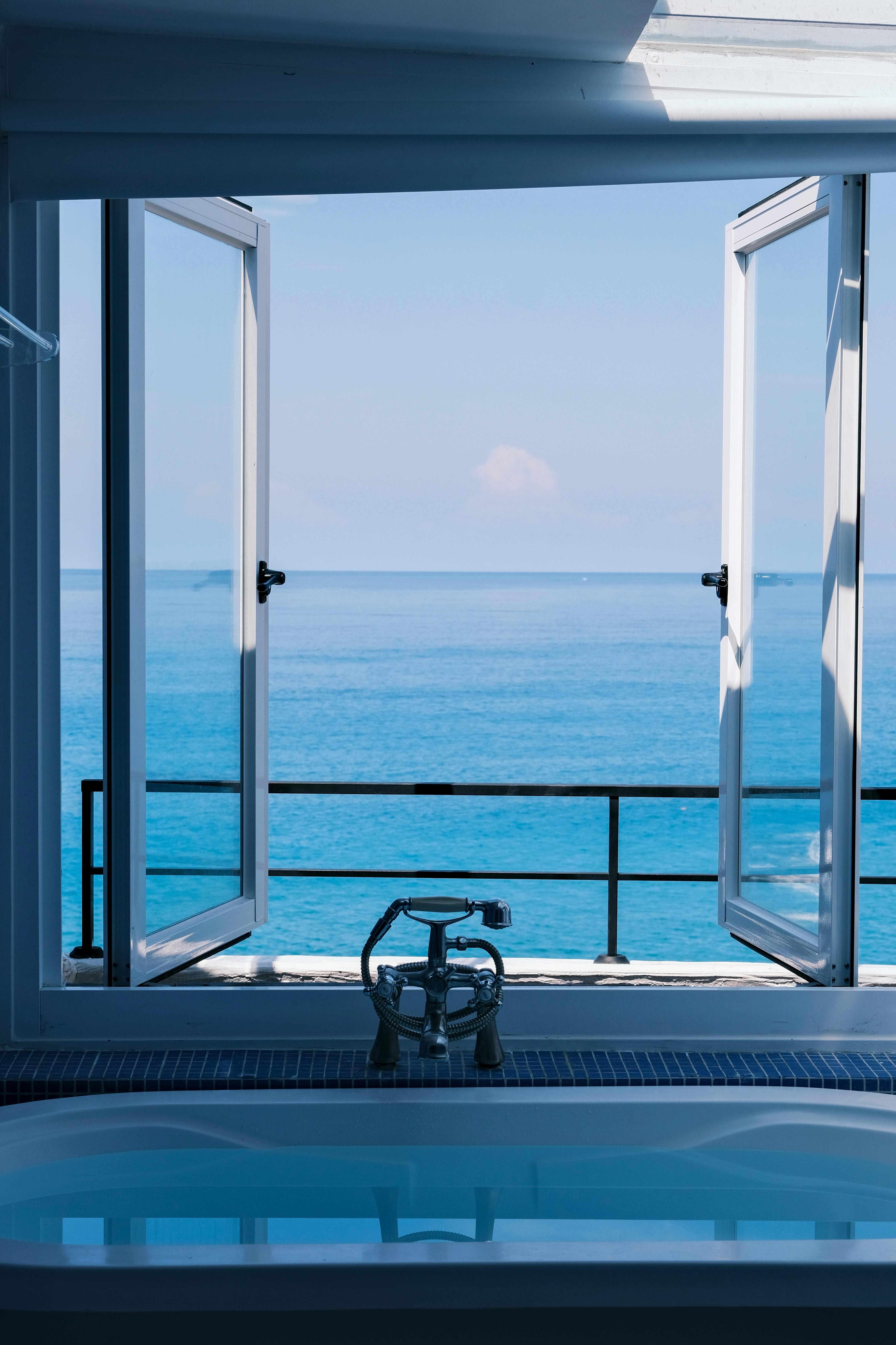 Coastal bathroom with open window and ocean view